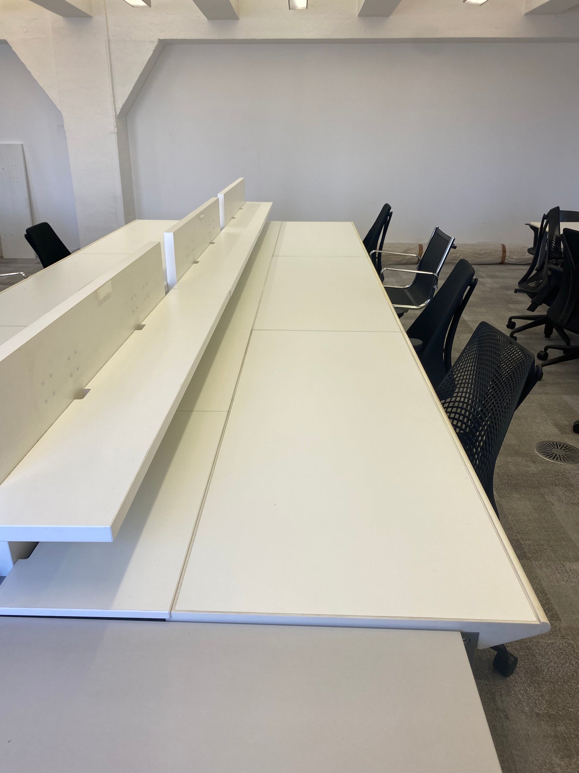 Black chairs and white office bench desks in white