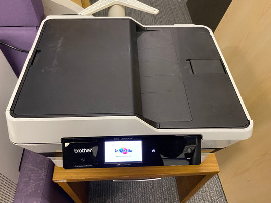 a Brother MFC-J6920DW Printer on top of a small coffee table