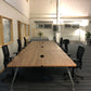 Walnut office bench desks with six black chairs in large hall