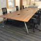 Walnut office bench desks with six black chairs