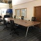 Walnut office benching workstations with six black chairs