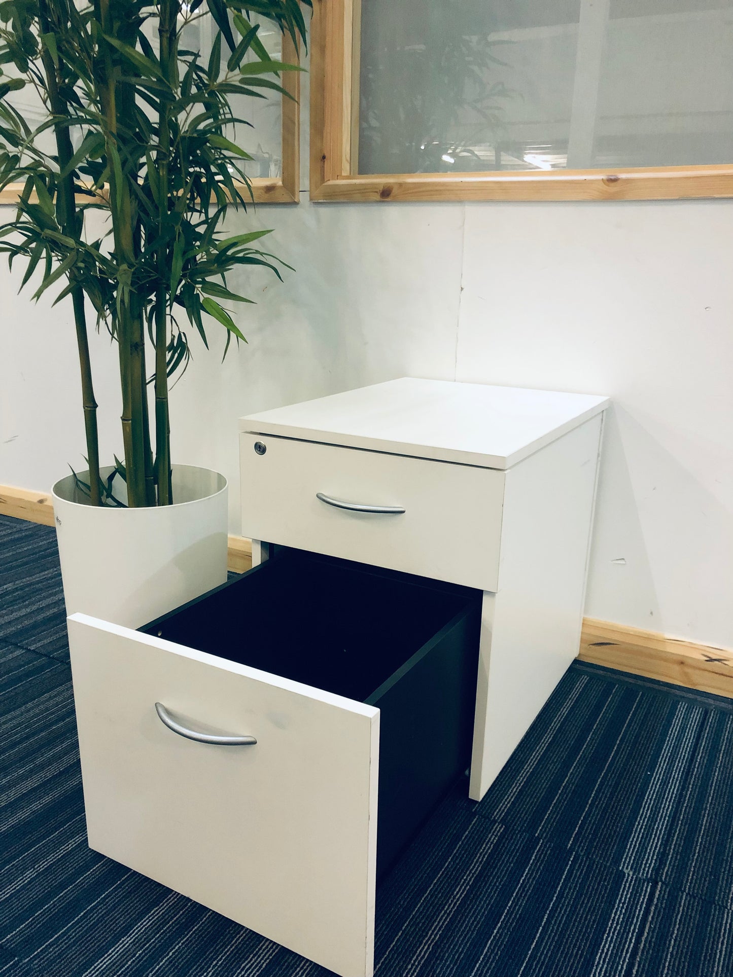 White cabinet with open lower drawer