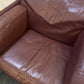 damaged seat of leather single armchair sofa with plant