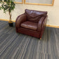 leather singe armchair sofa on carpet with plant on left