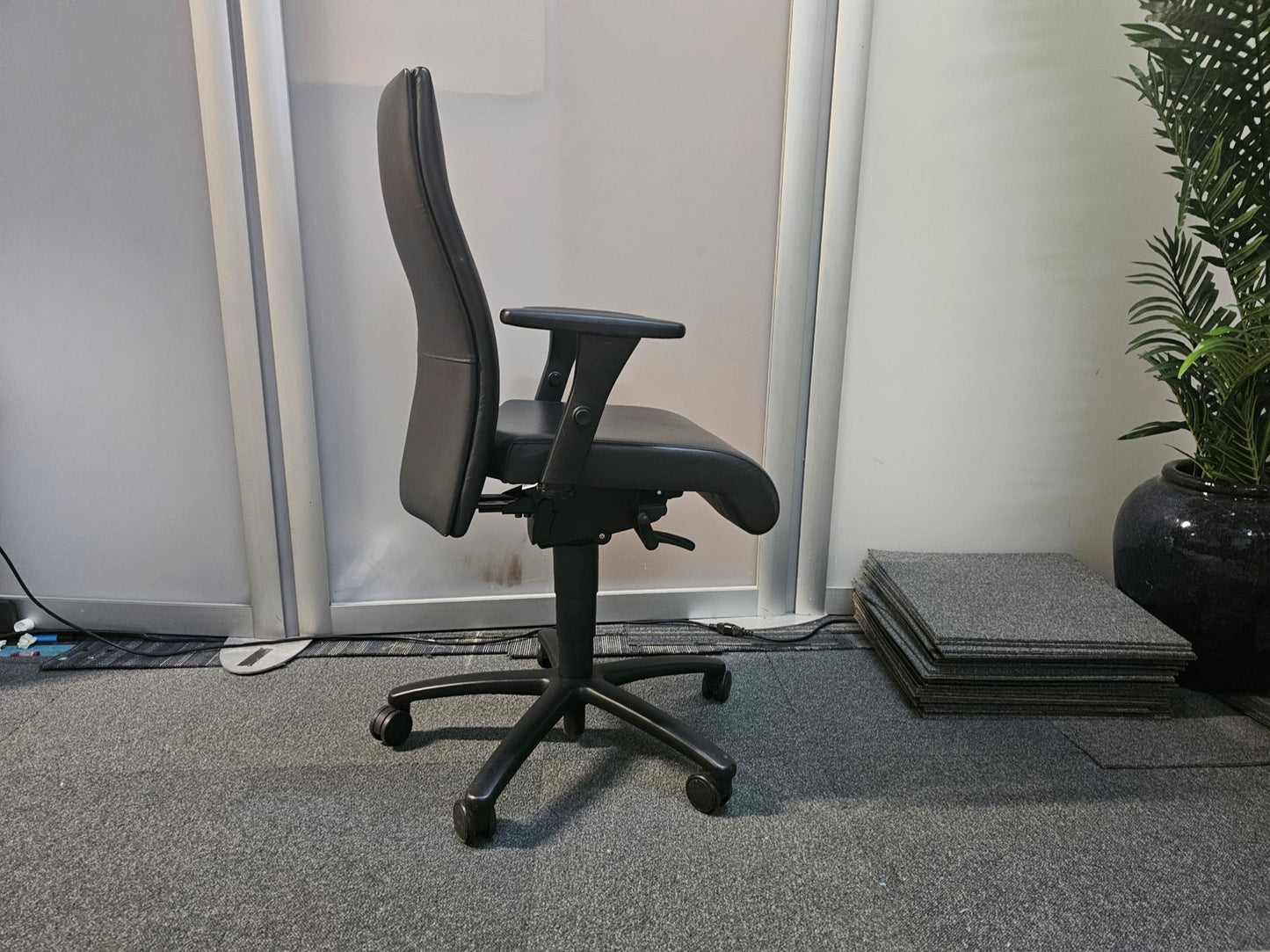 Black swivel desk chair in front of divider