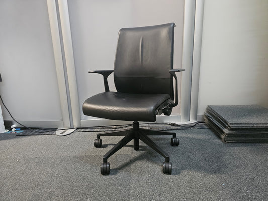 Leather swivel office chair in front of divider