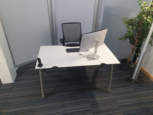 White office table with computer set up on top and black meshback office chair