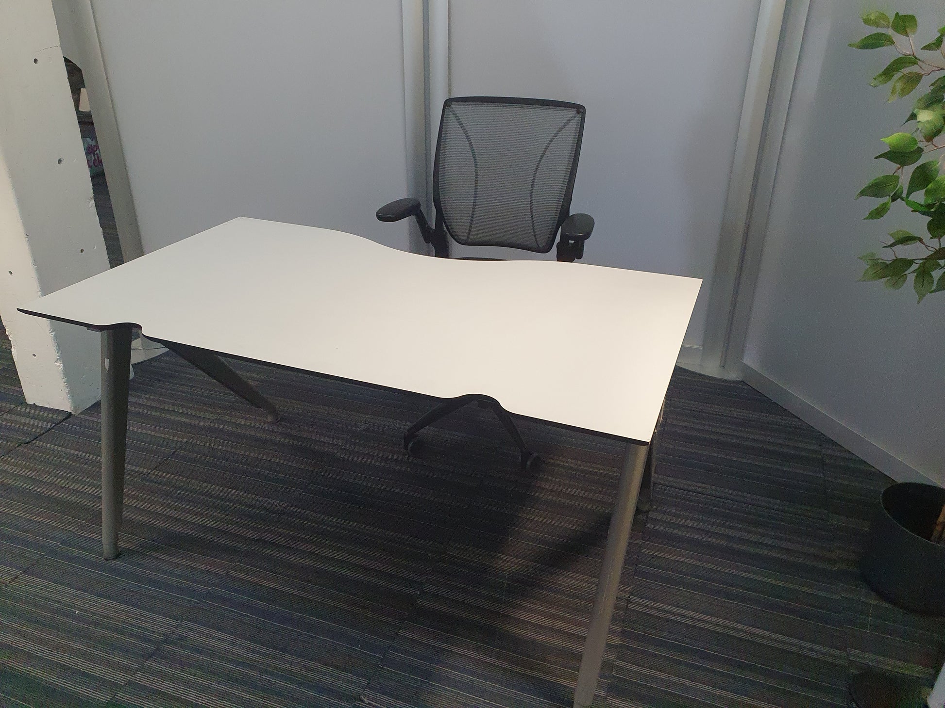Office desk and chair in front of transloucent dividers
