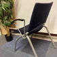 Back of blue chair with armrests and grey stick legs