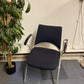 Stick chair with armrests next to a tall green plant