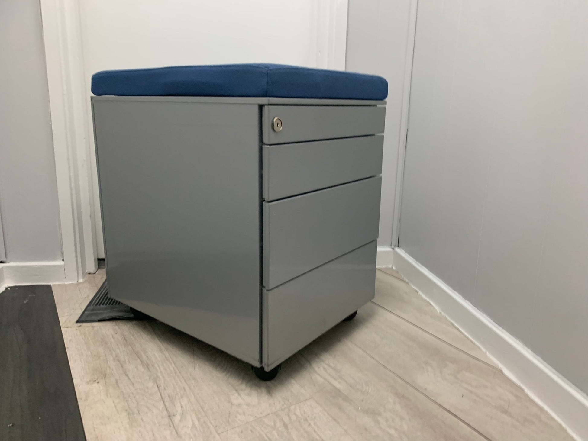 Grey and blue office filing cabinet on tiling