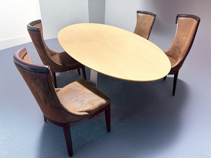 Secondhand maple-coloured boardroom table features a distinctive oval shape supported by four silver legs.