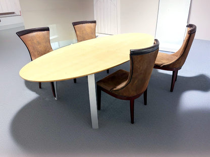 Secondhand maple-coloured boardroom table features a distinctive oval shape supported by four silver legs.