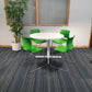 Green cantilever dining chairs around white table