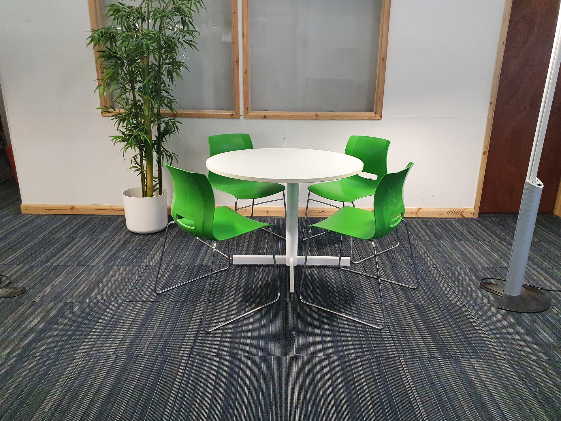 Green cantilever dining chairs around white table