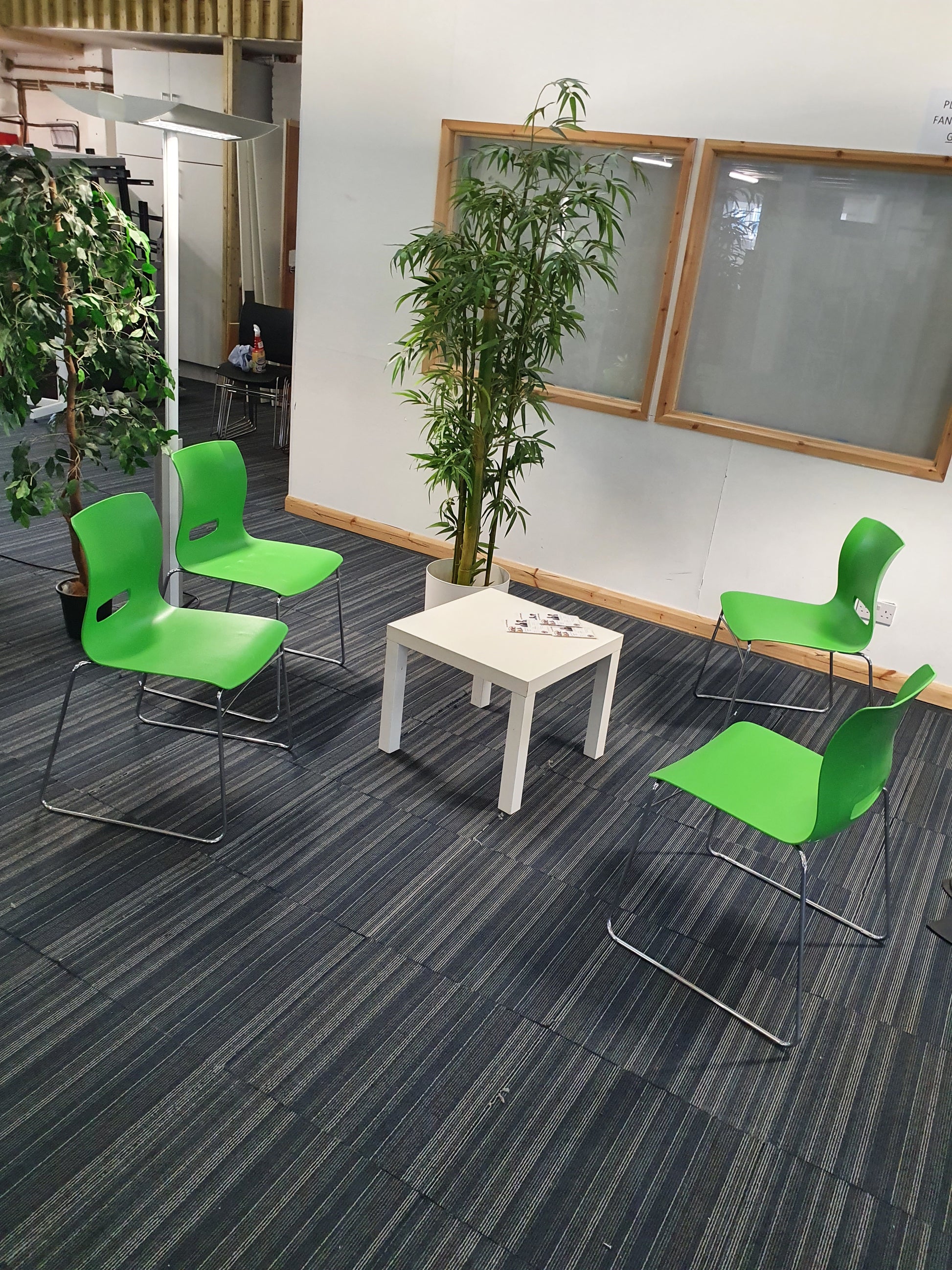 Green cantilever dining chairs around white coffee table