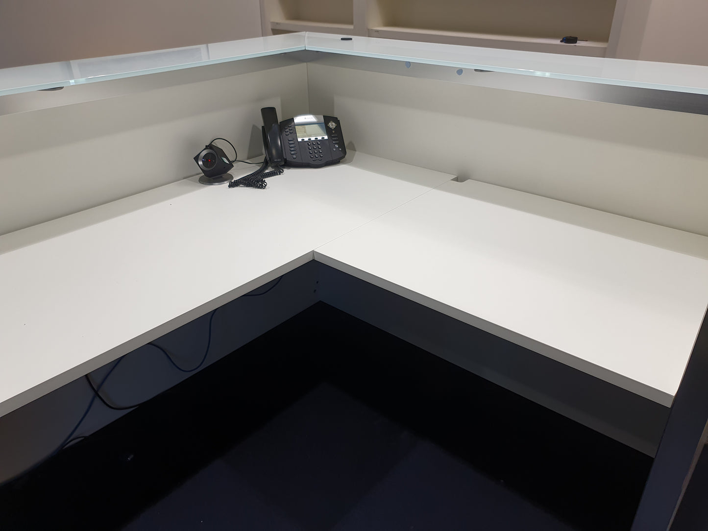 white reception table with counter and phone in centre