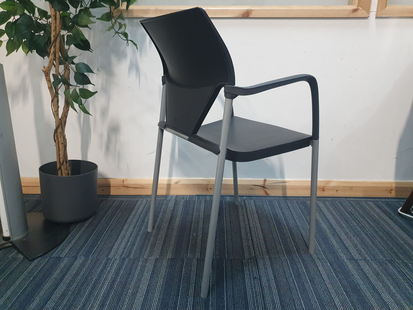 office meeting stick chair in black with armrests with plant on side