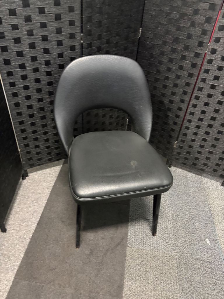 Used vintage inspired, open-back armchair features black faux leather upholstery
