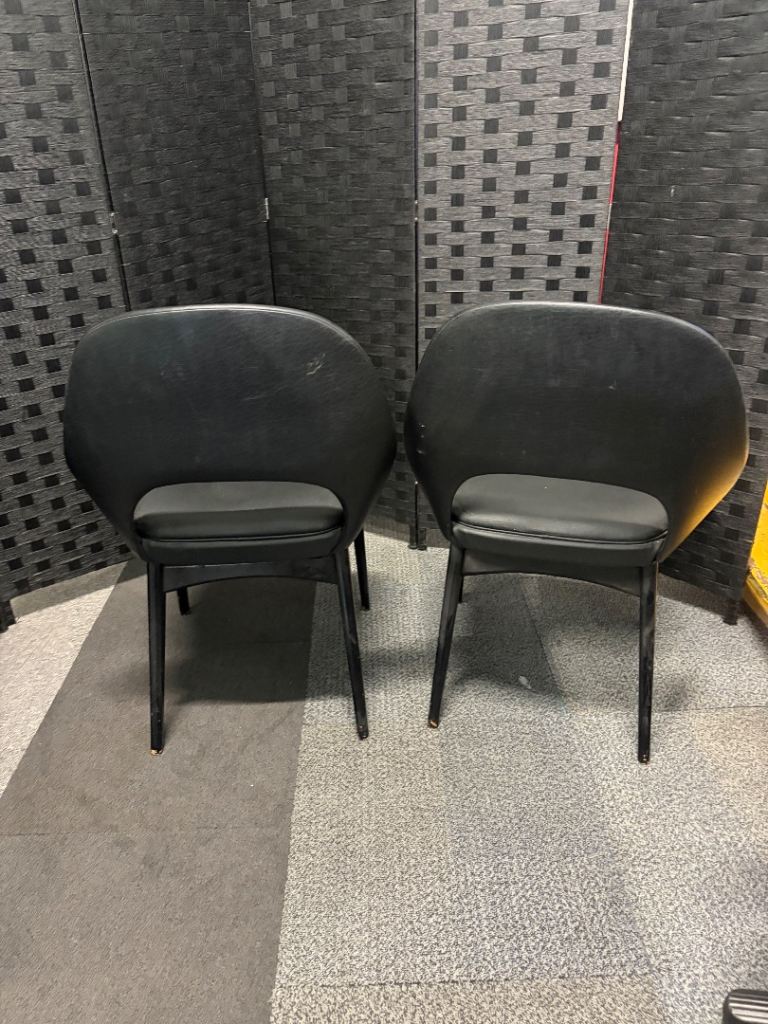 Used vintage inspired, open-back armchair features black faux leather upholstery