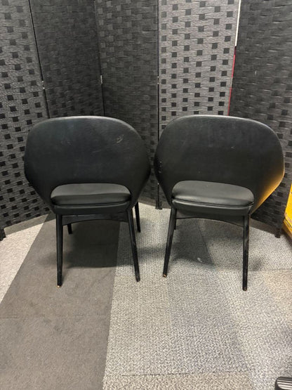 Used vintage inspired, open-back armchair features black faux leather upholstery