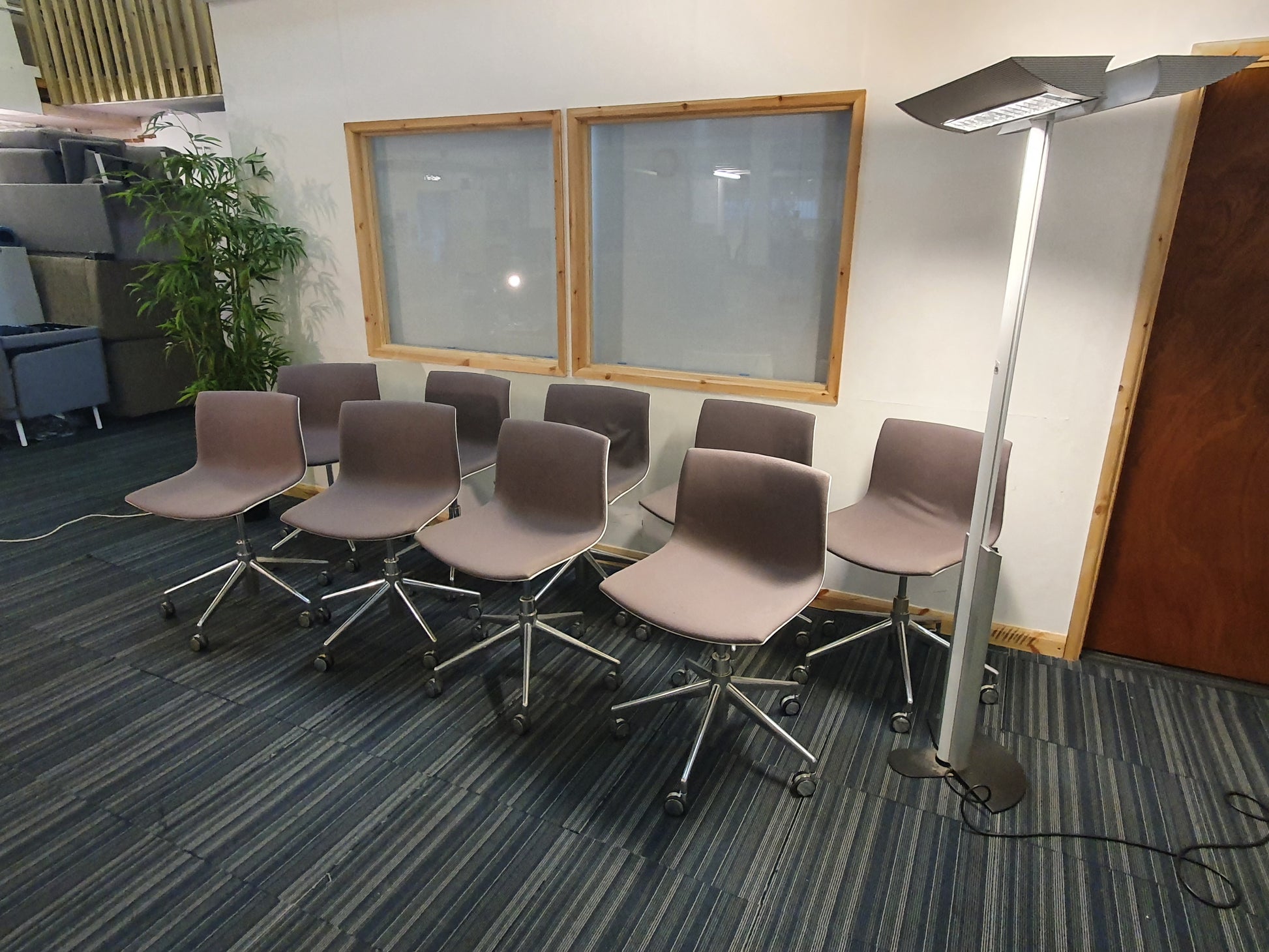 Left, stacked grey sofas and tall green plant, centre, nine Lievore Altherr Molina Arper Catifa Swivel Chair, right, tall lamp