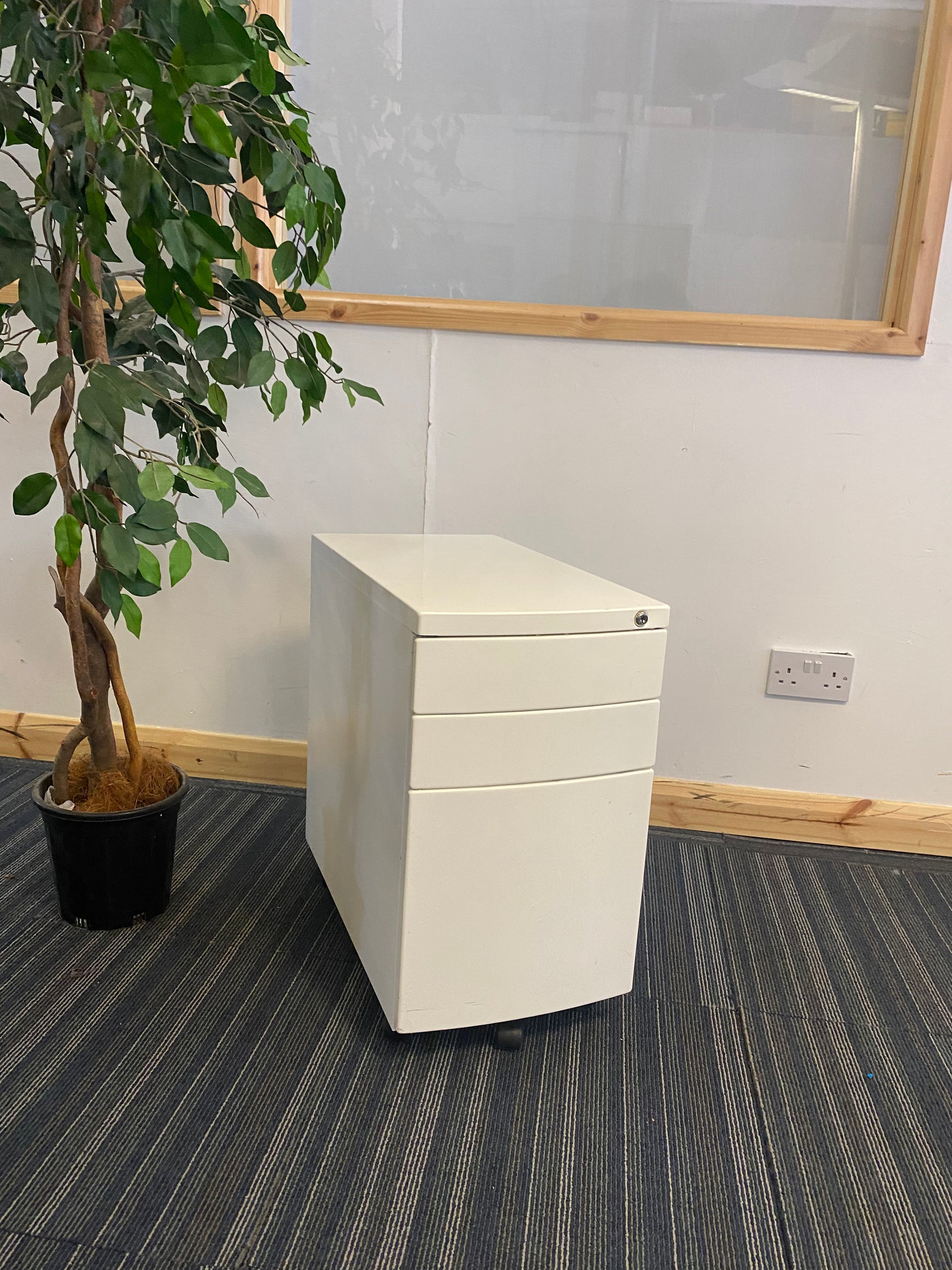 Left, tall green plant, centre, White under desk office drawer