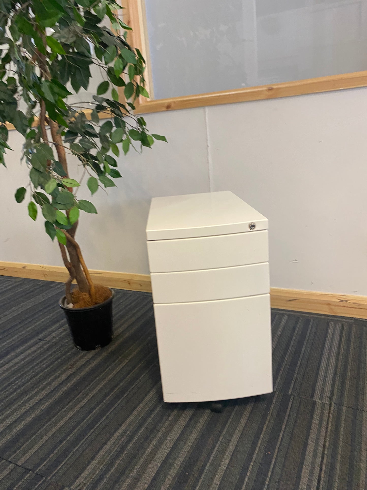 Left, tall green plant, centre, White under desk office drawer