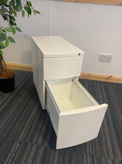 Left, tall green plant, centre, White office drawer with open third, bottom drawer